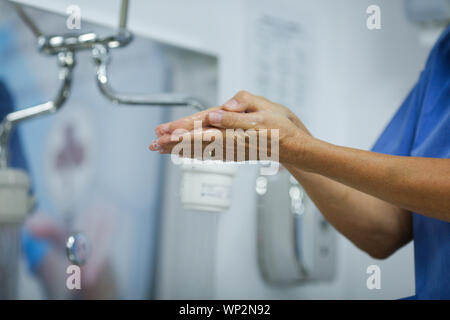 Détails avec un infirmier à laver ses mains avant un acte médical Banque D'Images