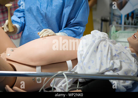 Détails avec un mannequin en plastique représentant une femme donnant naissance utilisés par les médecins et sages-femmes pour la pratique Banque D'Images