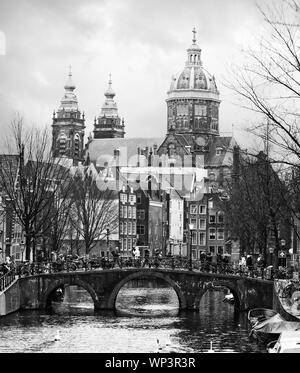 Oudezijds Voorburgwal canlal dans le centre d'Amsterdam. Dans l'arrière-plan Basilique de Saint Nicholas. Le noir et blanc Banque D'Images