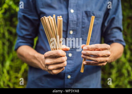 Le bambou paille pailles jetables vs dans les mains. Concept Zéro déchet Banque D'Images