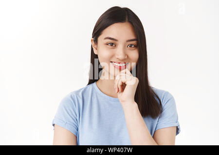 Offres et demandes de création intelligente étudiante de l'université fille réfléchir à de nouvelles idées en souriant heureux touch chin look sérieux amusé intrigué wanna remplir l'appareil photo Banque D'Images