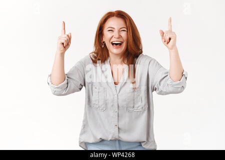 Haha tellement cool. Excité amusé et heureux douce rousse femelle d'âge moyen rire joie Bonheur modèle lever les mains vers le haut espace copie promo cam Banque D'Images