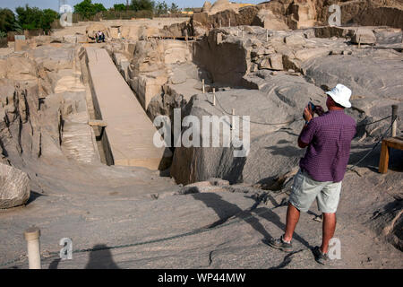 Un touriste prend une photo de l'Obélisque Inachevé à l'ouest de l'ancienne carrière à proximité d'Assouan en Égypte. Banque D'Images