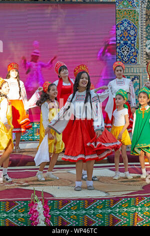 Boukhara, Ouzbékistan. Les enfants vêtus de costumes traditionnels ouzbek et russe, danse russe et de l'Ouzbek folk et chansons traditionnelles. Banque D'Images