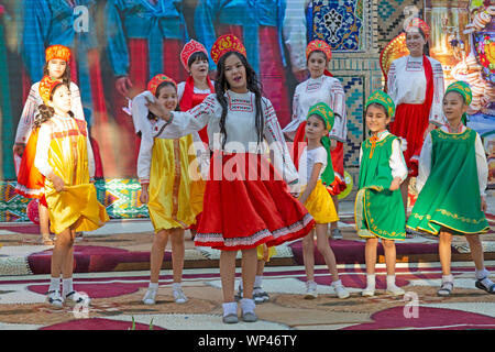 Boukhara, Ouzbékistan. Les enfants vêtus de costumes traditionnels ouzbek et russe, danse russe et de l'Ouzbek folk et chansons traditionnelles. Banque D'Images