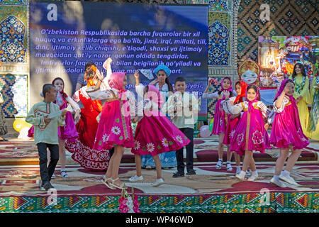 Boukhara, Ouzbékistan. Les enfants vêtus de costumes traditionnels ouzbek et russe, danse russe et de l'Ouzbek folk et chansons traditionnelles. Banque D'Images