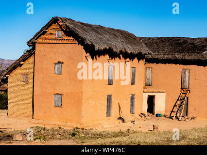 Typique de brique de boue traditionnelle en adobe construite de maisons de deux étages dans un petit village dans les hauts plateaux du centre de Madagascar. Briques orange foncé Banque D'Images