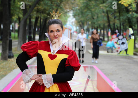 Jolie fille vêtue comme une reine de coeur du Pays des Merveilles pose sur le boulevard Tverskoï de Moscou. Personnage de conte de fée de Lewis Carroll Banque D'Images