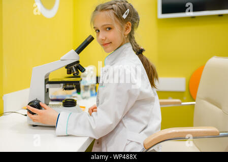 Fille au microscope, jouant médecin, salle de jeux Banque D'Images