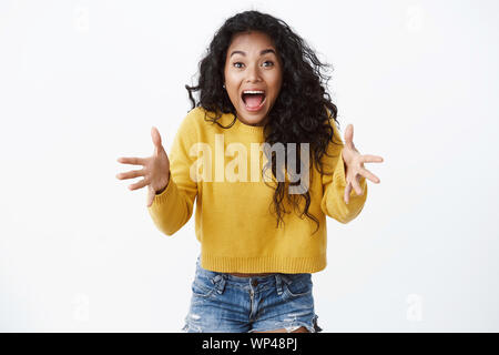 Attrayant émotionnelle aux cheveux bouclés afro-américaine fille look alarmés, de cris et d'élever les mains en stare choqué et troublé qu'observant quelque chose f Banque D'Images