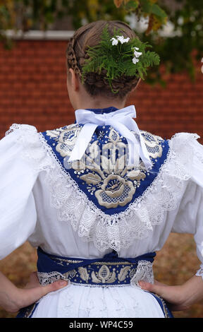 Vêtus de costumes folkloriques fille aller à l'église à la messe le jour de Thanksgiving à Stitar, Croatie Banque D'Images