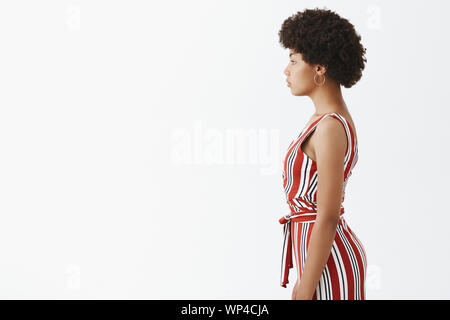 Grand Corps, se tenir en forme en été. Photo de profil moderne élégante African American Woman in trendy salopette rayée avec coiffure afro, lo Banque D'Images