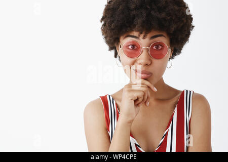 Élégant et célèbre designer de mode de la planification de nouveaux vêtements en ligne. Portrait de bon à la African American vogue dans les lunettes de soleil, tenant la main sur un menton Banque D'Images