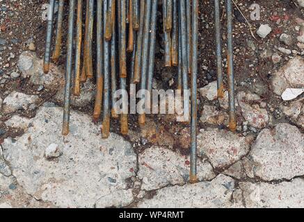 Tas de barres d'acier ronde avec la rouille sur un terrain au site de construction. Banque D'Images