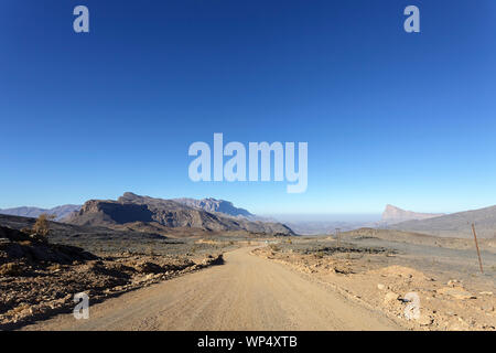 Chemin de terre et les pittoresques formations rocheuses des montagnes de Jebel Shams, Oman Banque D'Images