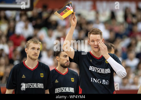 Shanghai, Chine. 07Th Nov, 2019. Basket-ball : WM, Allemagne - Sénégal, de placement à l'Oriental ronde centre sportif. L'Allemagne Robin Benzing (r) est titulaire d'un fanion avec le drapeau allemand après l'hymne national et s'intéresse à l'œil. L'Allemagne Niels Giffey (l) et d'Ismet Akpinar sont à côté d'eux. Credit : Swen Pförtner/dpa/Alamy Live News Banque D'Images