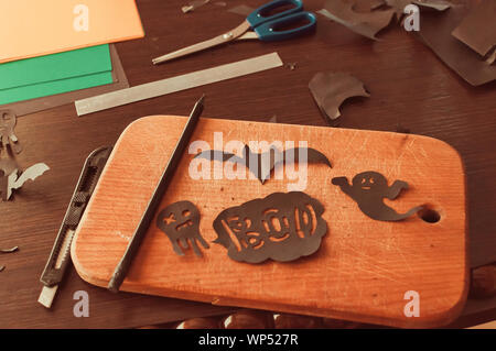 De l'artisanat pour l'halloween concept. Black bat et ghost figures sculptées du noir sur une planche de bois. Vue de dessus Banque D'Images