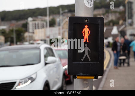 L'homme rouge et vert à un passage pour piétons que les voitures attendre les lumières pour changer. Banque D'Images