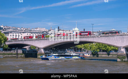 Waterloo Bridge pendant les heures de pointe sur clear spring day ; plusieurs autobus à impériale s'affichent dans la partie supérieure du pont et bateau de plaisance circulant sous c Banque D'Images