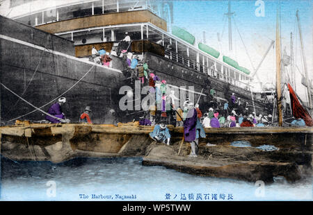 [ 1900 - Japon Coaling un navire à vapeur à Nagasaki ] - travailleurs des ports de haute qualité chargement charbon Kyushu sur un navire à Nagasaki. Dès que les navires du port de Nagasaki entré, des centaines d'hommes, femmes, filles et garçons fourmillaient autour d'eux sur danpeibune 団平船 (barges de charbon). Ils ont ensuite construit des structures temporaires et commencé à charger les navires de la faim avec le charbon. 20e siècle vintage carte postale. Banque D'Images