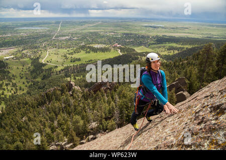 Mylène Jacquemart monte sur la 5ème face nord-est du Flatiron (5,6) que la pluie tombe sur Boulder, Colorado. Banque D'Images