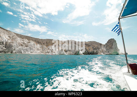 Brandir le drapeau grec à l'arrière d'un bateau dans la mer Banque D'Images