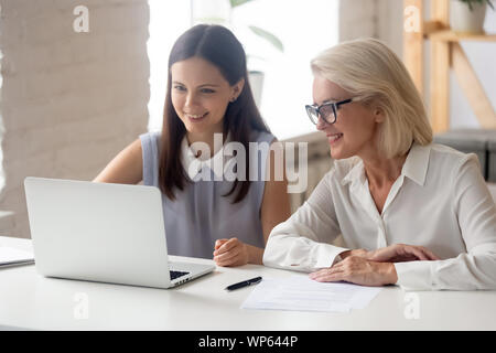 Female employés travaillent ensemble at laptop in office Banque D'Images
