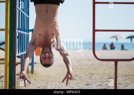 L'homme tête en bas à la plage en Grèce Banque D'Images