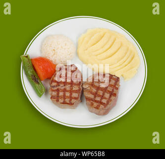 Une assiette de steak grillé avec purée de pommes de terre, riz, légumes sur fond vert Banque D'Images