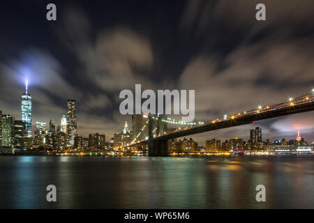 Manhattan skyline avec tour de la liberté et pont de Brooklyn de nuit. Banque D'Images