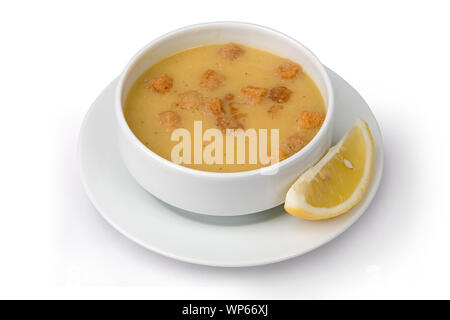 La soupe aux lentilles avec des croûtons dans un bol et le citron isolé sur fond blanc Banque D'Images
