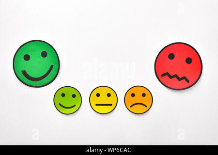 Représentation conceptuelle de doute, d'approbation ou de désapprobation avec les compressions de faces sur un tableau blanc. Composition horizontale. Vue d'en haut. Banque D'Images