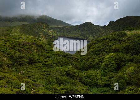 Image aérienne de Lagoa Comprida caldera crater lake entourée par la végétation verte et avec un ciel d'orage sur l'Ilha das Flores Island au Açores, P Banque D'Images