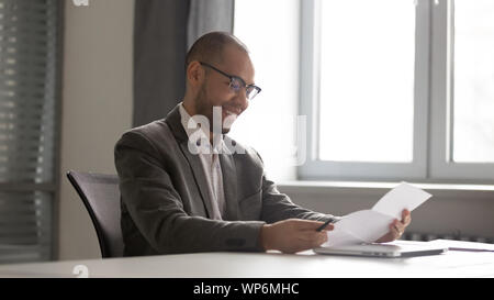 Happy african american male executive manager d'examiner les détails du contrat. Banque D'Images