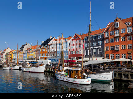 Beau vieux bateaux et voiliers dans le canal de Nyhavn populaires. Les maisons aux couleurs vives. Restaurants et bars bondées de touristes et visiteurs. Banque D'Images