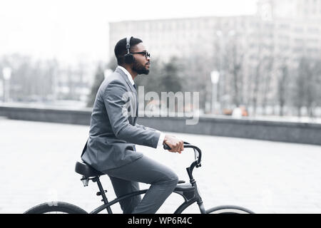 Jeune homme avec un casque équitation location on city street Banque D'Images