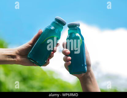 Les boissons isotoniques bleu pour vous rafraîchir en été dans les mains femme Banque D'Images