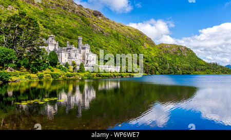 L'Abbaye de Kylemore, beau château abbaye comme reflété dans le lac au pied d'une montagne. Monastère bénédictin fondé en 1920, dans le Connemara, Irlande Banque D'Images