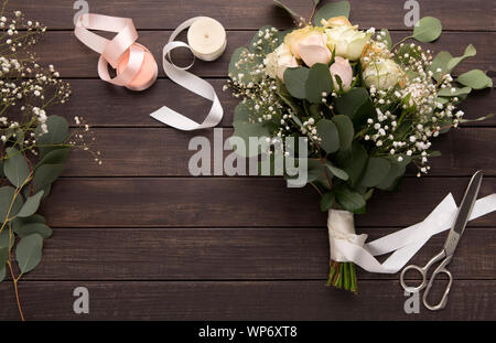 La création de bouquet de roses avec ruban rose sur bois Banque D'Images