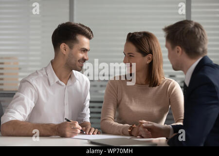 Les jeunes mariés heureux couple famille prendre une décision avant la signature du contrat. Banque D'Images