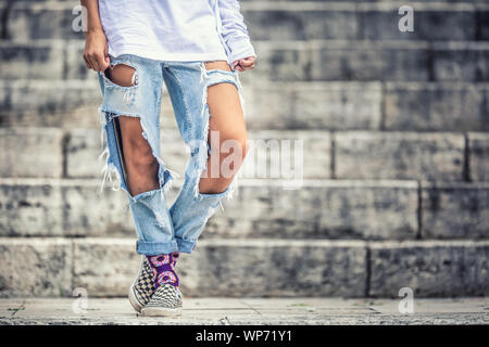 Jeans avec des trous larges sur les jambes d une jeune adolescente Photo Stock Alamy