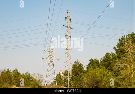 Transmission de puissance haute tension ligne sous un ciel bleu, un jour ensoleillé Banque D'Images