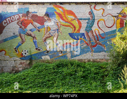 Des murs en mosaïque en mauvais état soviétique illustrant les sports le bâtiment dans le SKA sporting compelx à Lviv, Ukraine. Montrant le football et la gymnastique Banque D'Images
