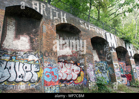 Des graffitis sur des talus en brique, parc à pied, une ancienne ligne de chemin de fer maintenant une réserve naturelle urbaine, Département du Nord-Ouest Banque D'Images