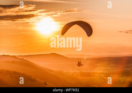 Devils Dyke, Brighton, Sussex, Royaume-Uni..7 septembre 2019. Pilote de parapente volant sur le vent Du Nord au-dessus des magnifiques South Downs alors que la brume se déplace. . Banque D'Images