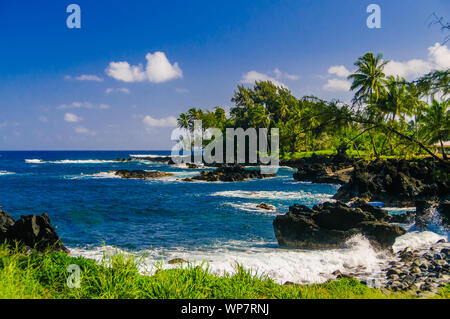 Vagues se brisant sur les rochers sur une journée ensoleillée au cours d'une spectaculaire vue sur l'océan sur la route de Hana, Maui, Hawaii, USA Banque D'Images