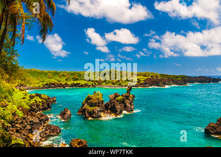 Vagues se brisant sur les rochers sur une journée ensoleillée au cours d'une spectaculaire vue sur l'océan sur la route de Hana, Maui, Hawaii, USA Banque D'Images