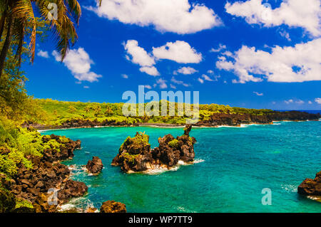 Vagues se brisant sur les rochers sur une journée ensoleillée au cours d'une spectaculaire vue sur l'océan sur la route de Hana, Maui, Hawaii, USA Banque D'Images