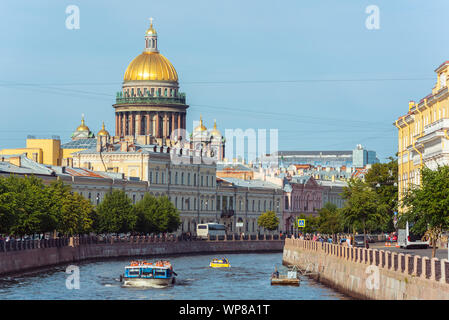 Saint Petersburg, Russie - le 18 août 2019 : la cathédrale Saint-Isaac et la vieille ville maisons le long de la rivière Moïka avec un bateau. Banque D'Images