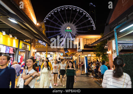 Bangkok, Thaïlande - le 28 juillet 2019 : une ruelle bondée à l'Asiatique The Riverfront dans la nuit, en vue de la grande roue. Banque D'Images